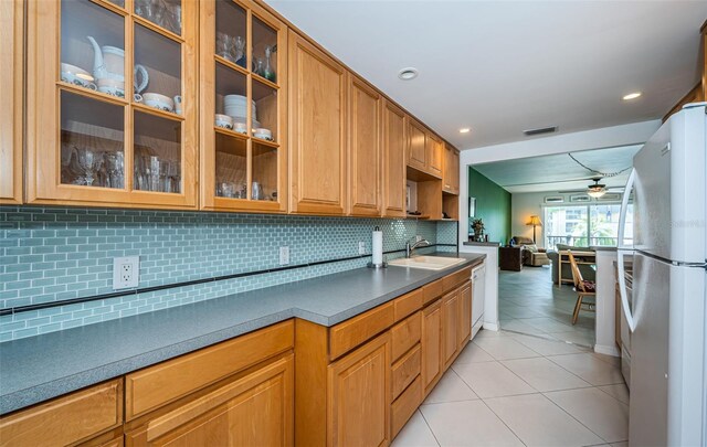 kitchen with ceiling fan, backsplash, light tile patterned floors, sink, and white appliances