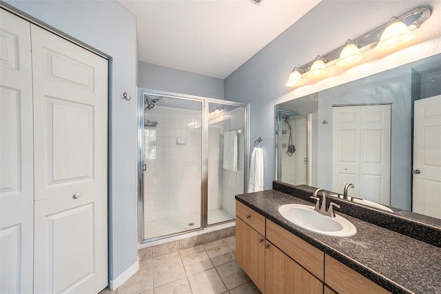 bathroom with tile patterned floors, an enclosed shower, and vanity