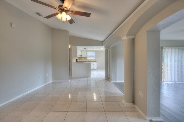 unfurnished living room with lofted ceiling, ornate columns, ceiling fan, and a healthy amount of sunlight