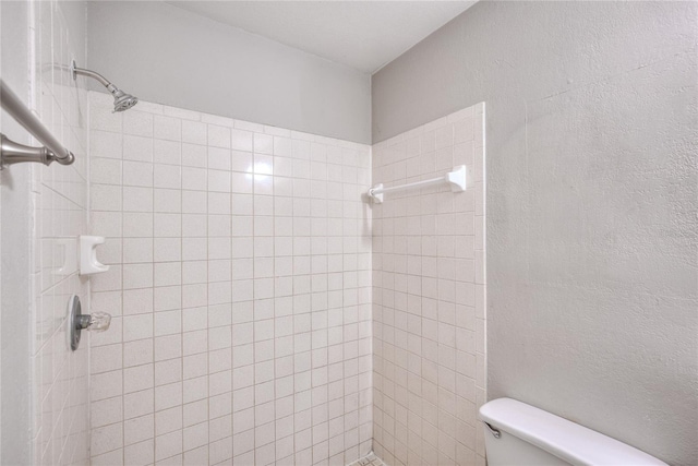 bathroom with tiled shower and toilet