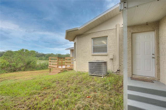 view of side of property with a lawn and central AC