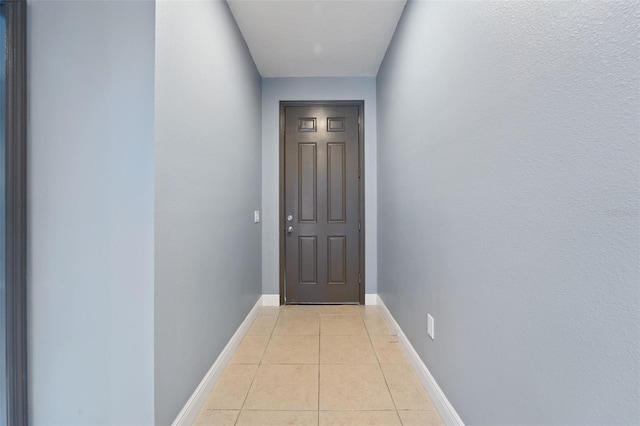 doorway to outside with light tile patterned floors and baseboards