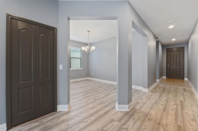 foyer entrance with a notable chandelier and light wood-type flooring