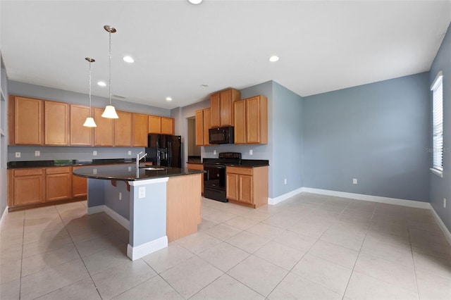 kitchen with a center island with sink, black appliances, pendant lighting, light tile patterned floors, and sink