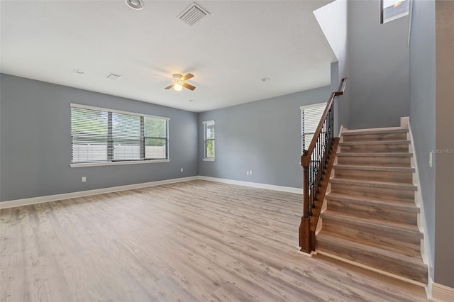 empty room with ceiling fan and light hardwood / wood-style floors