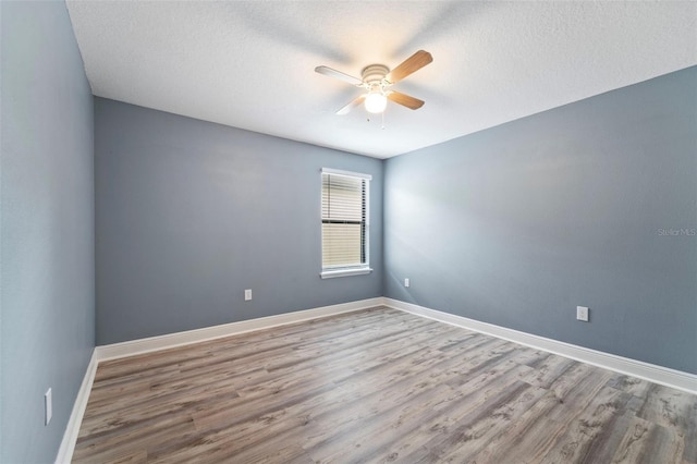 spare room featuring hardwood / wood-style floors, ceiling fan, and a textured ceiling