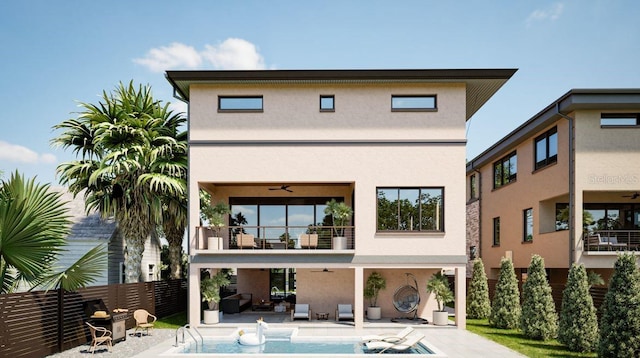 rear view of house with a balcony, ceiling fan, and a patio area