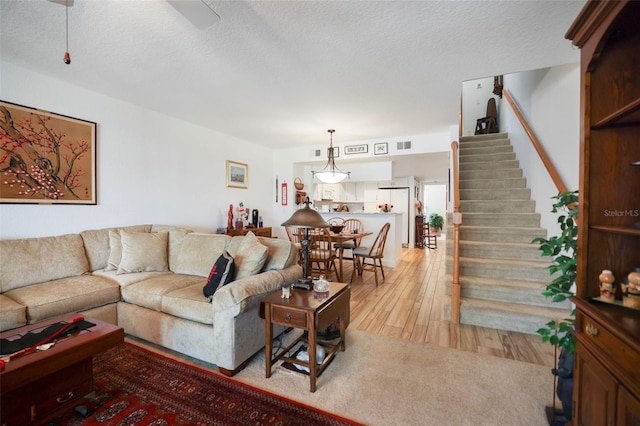 living room with a textured ceiling and light hardwood / wood-style floors