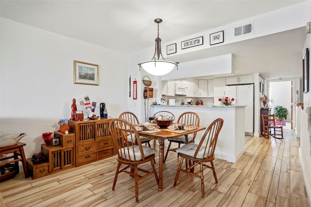 dining space featuring light wood-type flooring