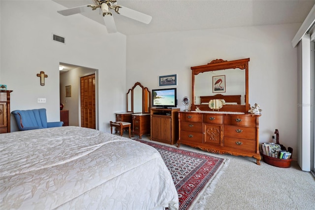 carpeted bedroom with high vaulted ceiling, ceiling fan, and a closet