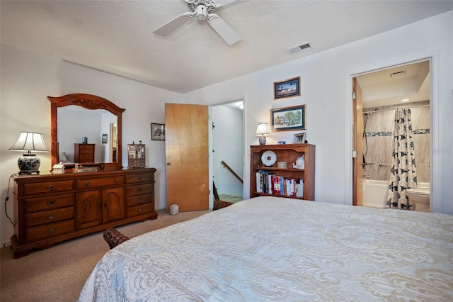 carpeted bedroom featuring a textured ceiling, ensuite bathroom, and ceiling fan