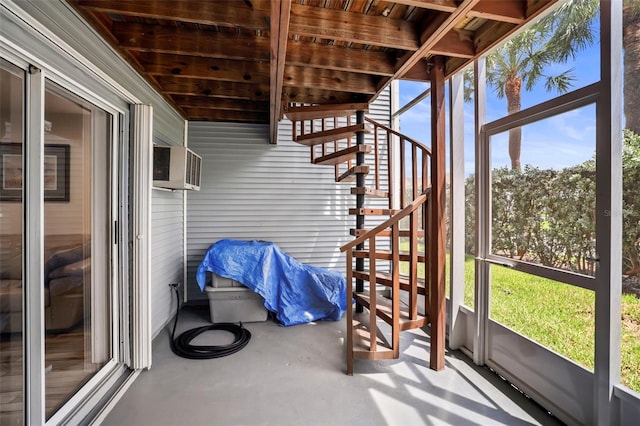 unfurnished sunroom with an AC wall unit and a healthy amount of sunlight