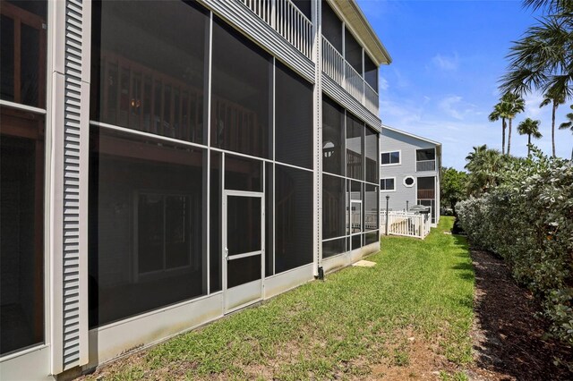 exterior space featuring a sunroom and a lawn