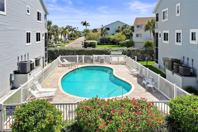 view of swimming pool with a patio area and central air condition unit