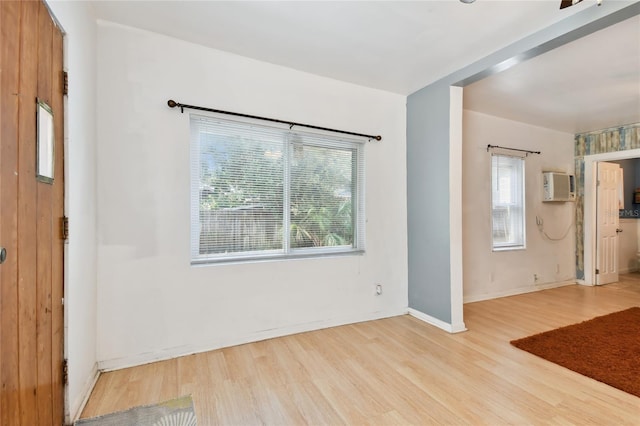 spare room featuring light hardwood / wood-style flooring and a wall mounted AC