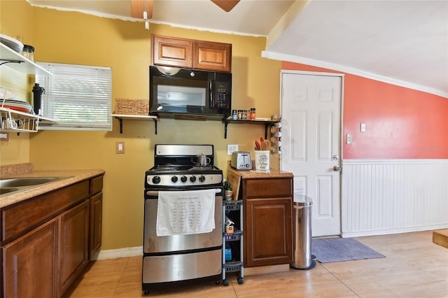 kitchen with lofted ceiling, gas range, ornamental molding, and sink