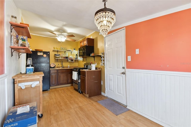 kitchen with ceiling fan with notable chandelier, decorative light fixtures, black appliances, sink, and light wood-type flooring