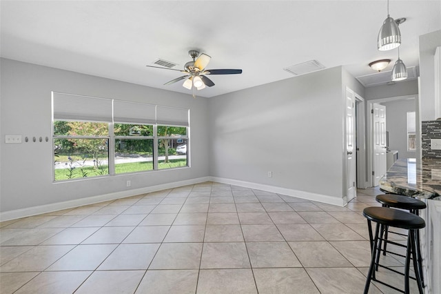 spare room with ceiling fan and light tile patterned floors