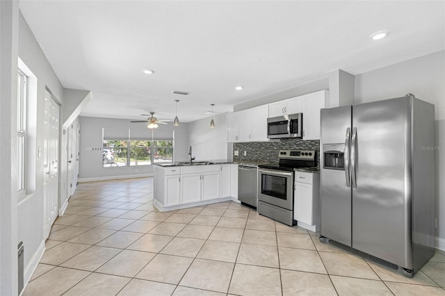 kitchen with stainless steel appliances, white cabinetry, kitchen peninsula, and sink