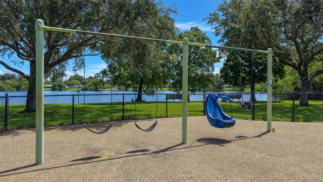 view of jungle gym with a lawn and a water view