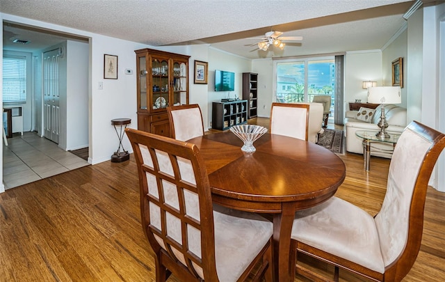 dining space with a textured ceiling, hardwood / wood-style floors, and ceiling fan