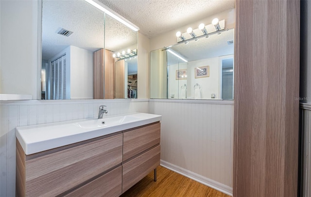 bathroom featuring hardwood / wood-style floors, vanity, and a textured ceiling