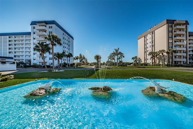 view of swimming pool featuring a lawn