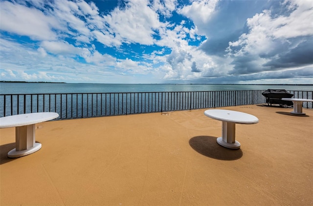 view of patio featuring a water view and a balcony