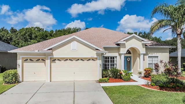 view of front of property with a garage, driveway, roof with shingles, and stucco siding