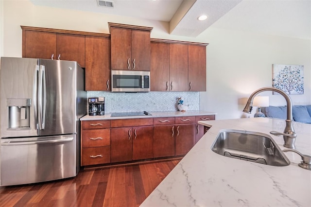 kitchen with light stone countertops, stainless steel appliances, dark hardwood / wood-style floors, and sink