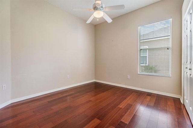 unfurnished room with ceiling fan, dark wood-type flooring, and baseboards