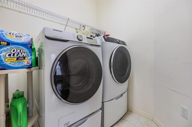 laundry room with light tile patterned floors and washing machine and dryer