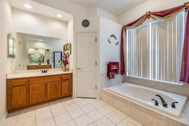 bathroom featuring a garden tub, tile patterned floors, a shower with door, and vanity