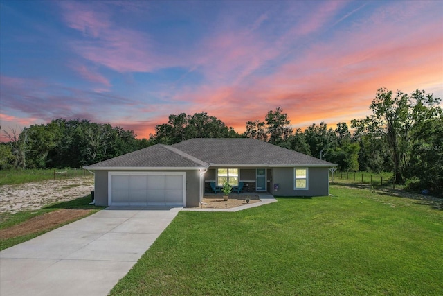 ranch-style home with a garage and a lawn