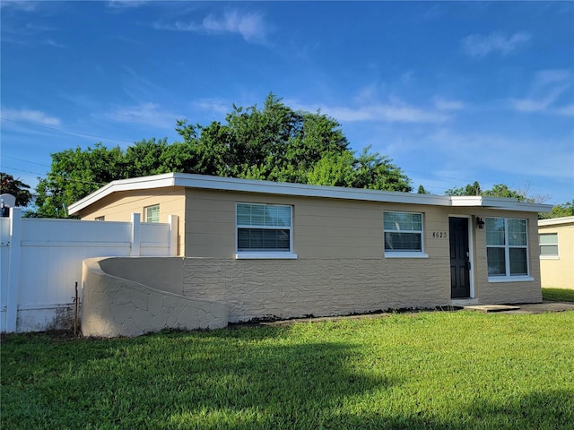 view of front of house with fence and a front lawn