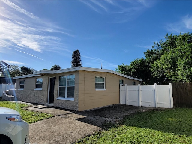 view of side of property featuring fence and a yard