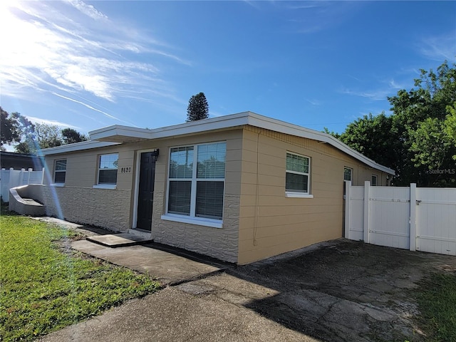 view of side of home featuring a gate and fence