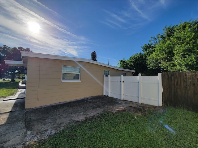 rear view of property featuring a lawn and fence