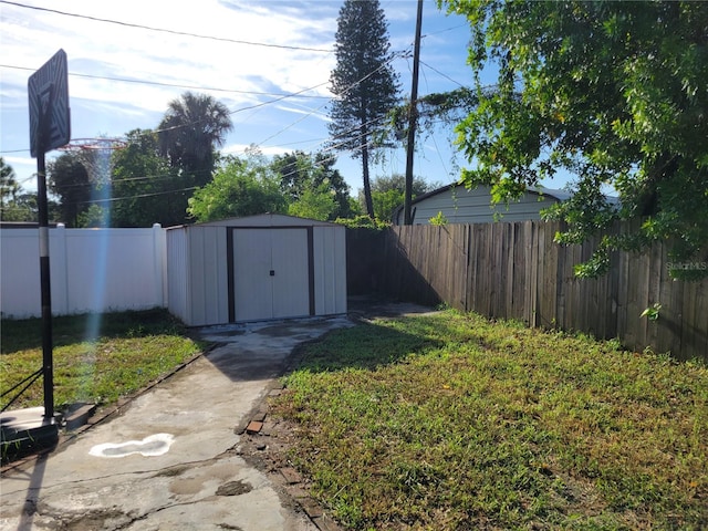 view of yard with a storage shed, an outbuilding, and a fenced backyard