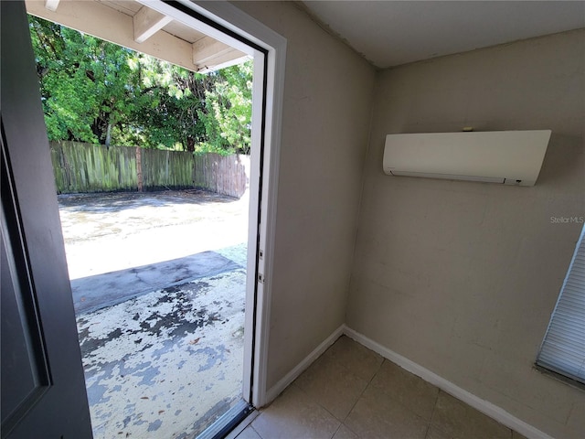 entryway with baseboards, a wall unit AC, and tile patterned floors