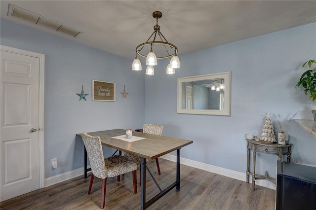 dining room featuring wood-type flooring and a notable chandelier