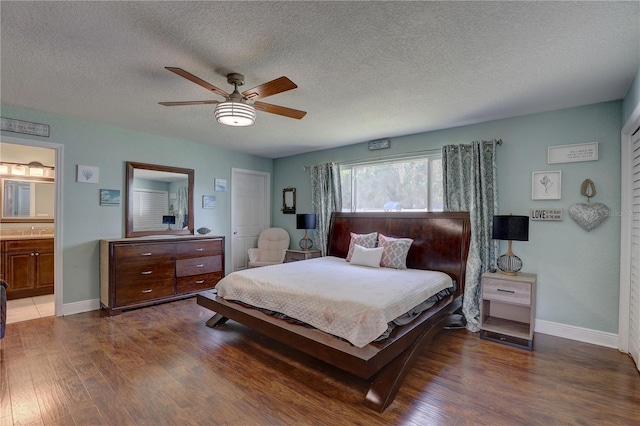 bedroom with a textured ceiling, ensuite bath, ceiling fan, and dark hardwood / wood-style floors