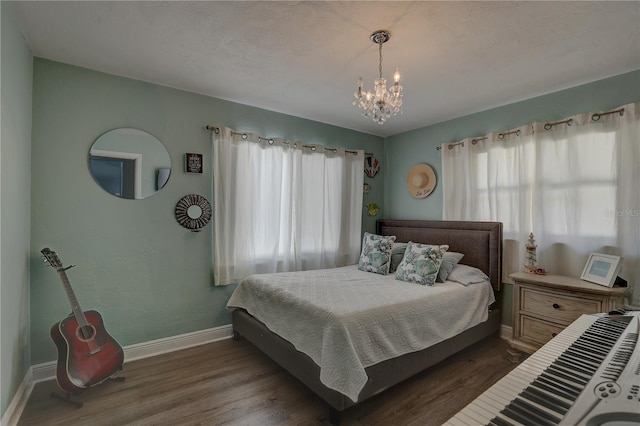 bedroom featuring dark wood-type flooring and an inviting chandelier