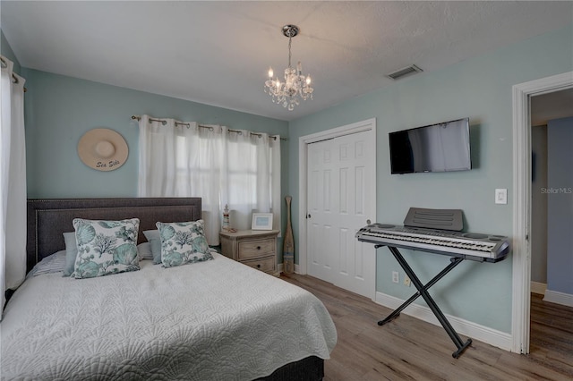 bedroom with a chandelier, light hardwood / wood-style floors, and a closet