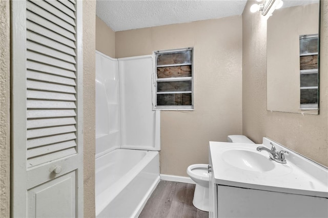 full bathroom with shower / bath combination, toilet, vanity, hardwood / wood-style floors, and a textured ceiling