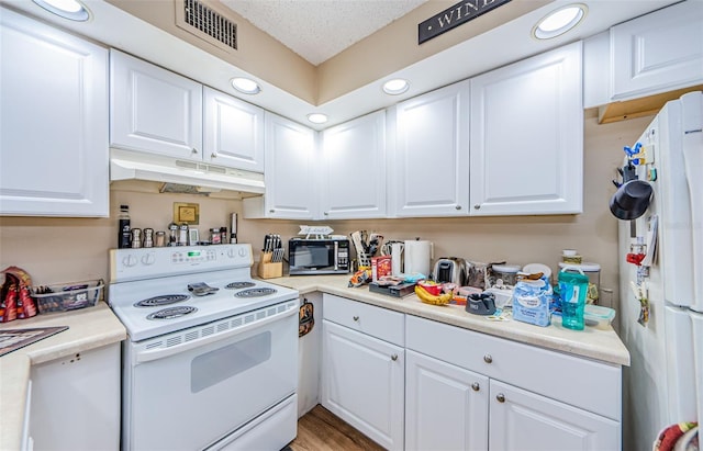 kitchen with light hardwood / wood-style floors, a textured ceiling, white appliances, and white cabinets