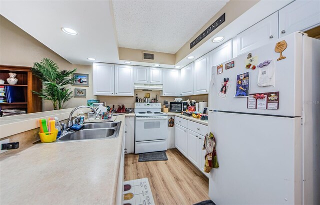 kitchen featuring sink, white appliances, light hardwood / wood-style floors, and white cabinetry