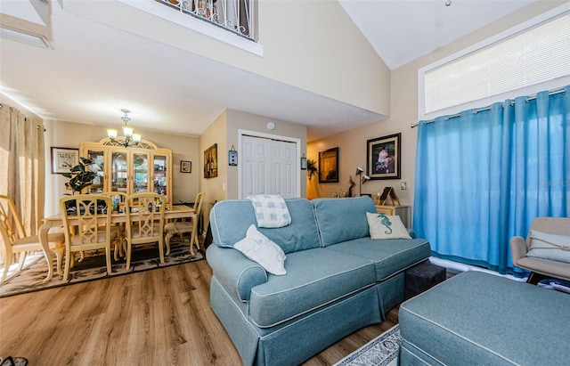 living room featuring hardwood / wood-style flooring, a notable chandelier, and a high ceiling