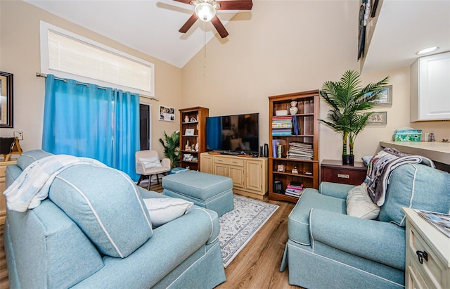 living room featuring light hardwood / wood-style flooring, ceiling fan, and high vaulted ceiling