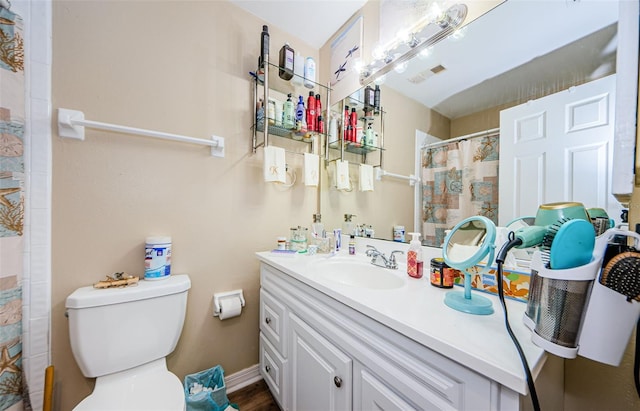 bathroom featuring a shower with shower curtain, visible vents, vanity, and toilet